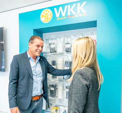 Ein WKK Mitarbeiter vor einem Regal mit WKK Kabelbindern, im Beratungsgespräch.